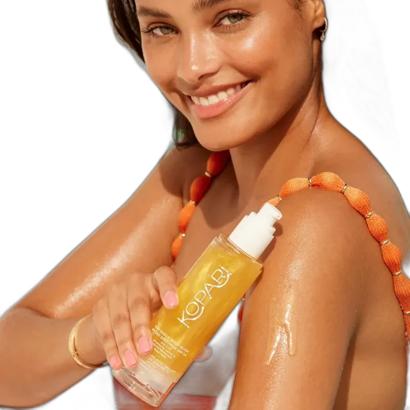 Kopari Sun Shield Body Glow SPF 50 in a white squeeze tube with gold shimmer accents